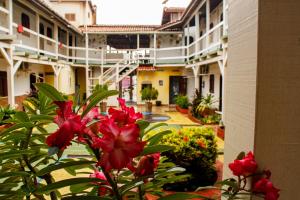 a group of buildings with red flowers in a courtyard at Hotel Tropicalia in Canoa Quebrada
