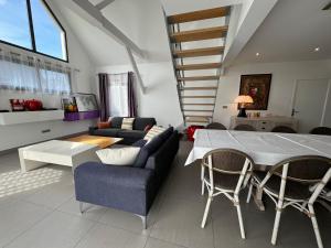uma sala de estar com uma mesa de jantar e cadeiras em Villa Benouville em Bénouville