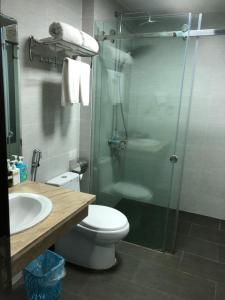 een badkamer met een douche, een toilet en een wastafel bij Hotel Nam Sơn Tân Dương in Chơ Mơi