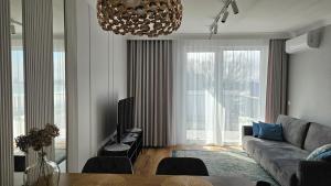 a living room with a couch and a large window at Apartament Elegance, Metro, free parking in Warsaw