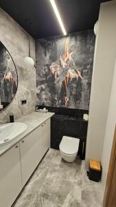 a bathroom with a white toilet and a sink at Apartament Elegance, Metro, free parking in Warsaw +5 photos