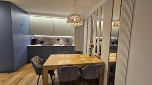a kitchen and dining room with a table and chairs at Apartament Elegance, Metro, free parking in Warsaw