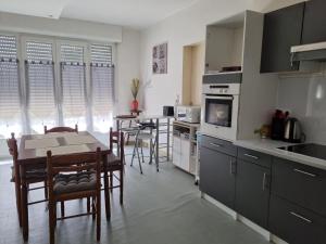 - une cuisine et une salle à manger avec une table et des chaises dans l'établissement Spacieux Appartement RDC tout confort, à Lorient