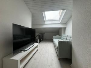 een woonkamer met een flatscreen-tv en een bank bij Joli T3 duplex Compans Cafarelli in Toulouse