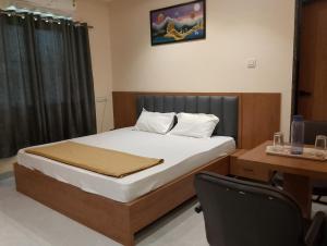 Bett in einem Zimmer mit einem Schreibtisch und einem Bett der Marke sidx sidx sidx. in der Unterkunft HOTEL PARADISE INN in Shinaya