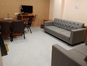 HOTEL PARADISE INN في Shinaya: غرفة معيشة مع أريكة وطاولة