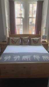 um quarto com uma cama com lençóis azuis e janelas em Ardvaich House em Oban