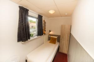 スロイスにあるHotel Le Provencalのベッドと窓が備わる小さな客室です。