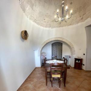 a dining room with a table and a chandelier at RosaLilli in Locorotondo +22 photos