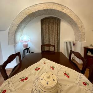 a dining room with a table and an archway at RosaLilli in Locorotondo