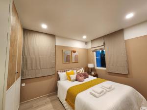 1 dormitorio con 1 cama blanca grande con almohadas amarillas en NARAH en Ban Thap Nang