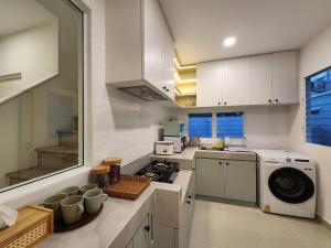uma cozinha com um lavatório, um fogão e um micro-ondas em NARAH em Ban Thap Nang