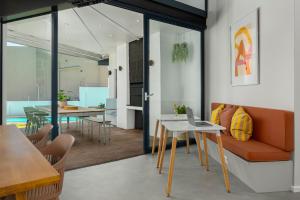 a living room with a couch and a table with a laptop at Neighbourgood 1st Crescent Camps Bay in Cape Town