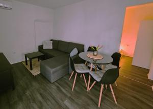 sala de estar con sofá, mesa y sillas en Apartment Port of happiness, en Krnica