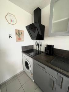 a kitchen with a sink and a washing machine at Appartement devant la mer + parking in Le Grau-du-Roi +9 photos