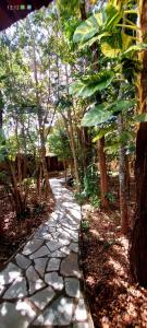 a stone path in a garden with trees at Cantinho do Cerrado in Pirenópolis
