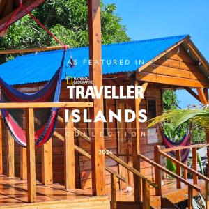 una hamaca en una terraza con un cartel que lee islas viajeras en Lighthouse Hotel and Spa, Little Corn island, Nicaragua en Little Corn Island