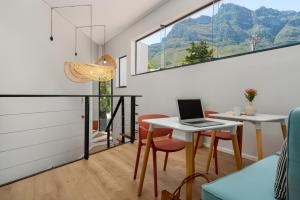 a room with a table with a laptop on it at Neighbourgood 1st Crescent Camps Bay in Cape Town