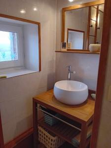 W łazience znajduje się umywalka i lustro. w obiekcie Gîte Sèvremoine Bois Buteau w mieście Montfaucon