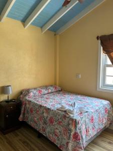 a bedroom with a bed with a floral bedspread at Casa del Rio in Panajachel