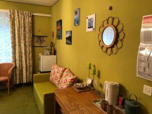 uma sala de estar com um sofá verde e uma mesa em Beachroom 19m2 with mountain view em Evilard