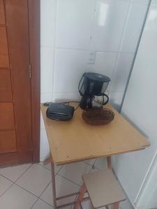 a small wooden table with a black appliance on it at Casa do Vô Luiz in Vila Velha