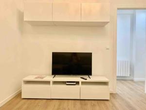 a white entertainment center with a television in a living room at Alhóndiga Flat by Next Stop Bilbao in Bilbao
