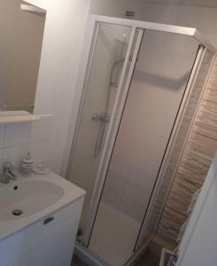 a white bathroom with a shower and a sink at Studio en rez-de-chaussée avec cour dans le centre de Vendome in Vendôme