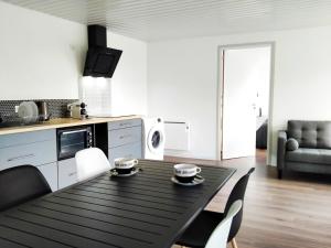 eine Küche mit einem schwarzen Tisch und Stühlen in einem Zimmer in der Unterkunft Mimis House in Lacanau