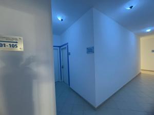 a hallway with a blue light on a wall at Garden Hotel Alghero in Fertilia