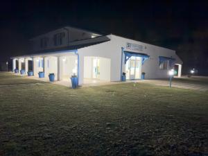 a white building with blue lights on it at night at Garden Hotel Alghero in Fertilia