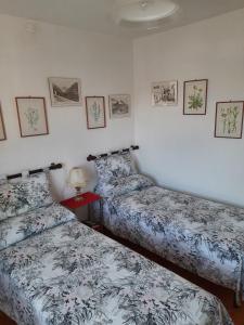 1 dormitorio con 2 camas y una lámpara en una mesa en Alloggio da Piero, en Blevy