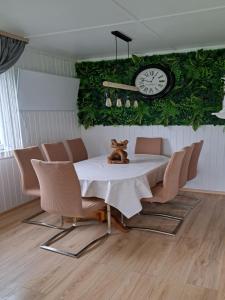 une salle à manger avec une table, des chaises et une horloge dans l'établissement Ferienhaus am Edersee-scheid, à Waldeck
