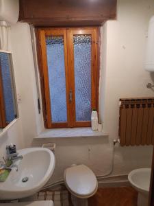 baño con lavabo y aseo y ventana en Alloggio da Piero en Blavy