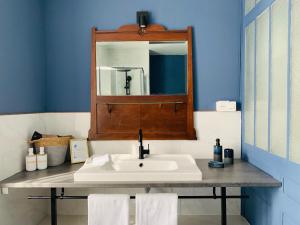 a bathroom with a sink and a mirror at Brigitte et Moi in Chancelade