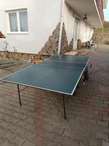 a ping pong table in front of a house at Casa Tonyza in Cisnădie