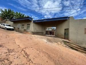 a car parked in front of a building on a dirt road at Hospedaria cmc unidade 05 com estacionamento in Brasilia