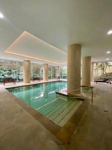 a large swimming pool in a building with columns at Apartaestudio cercano al aeropuerto. in Rionegro