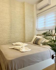 a bed in a room with two towels on it at "Calm Joy & J" - Family in Ermoupoli