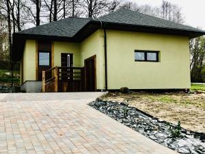 une petite maison jaune avec une terrasse couverte dans l'établissement Vila Veri 2, à Ostrava