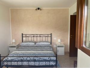 a bedroom with a bed with two nightstands and two lamps at Pezzelelle in Roccamorice