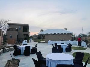 a group of tables and chairs with white table cloths at Nightingales Resort in Nāthdwāra