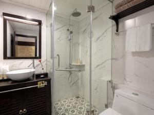 W łazience znajduje się szklana kabina prysznicowa i umywalka. w obiekcie Hạ Long Aqua Legend Cruise w Ha Long