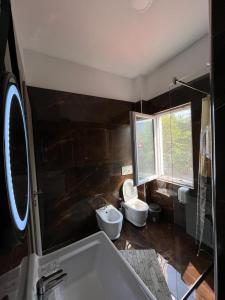uma casa de banho com 2 WC, um lavatório e uma banheira em Lundra em Gramsh