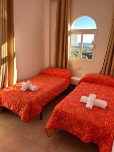 2 camas en una habitación con ventana en Imperial Puerto, en Torremolinos