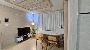 a living room with a table and a television at My comfortable second house in Seoul