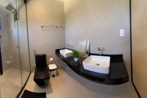 CamassariにあるCasa Alto Padrão Praia Guarajubaの白い洗面台と鏡のあるバスルーム +32枚の写真