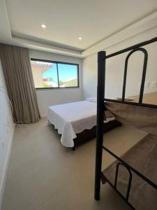 CamassariにあるCasa Alto Padrão Praia Guarajubaのベッドと窓のある寝室