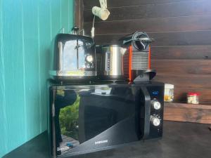 un forno a microonde con una macchinetta del caffè sopra di Charmant bungalow avec piscine a Saint-Joseph