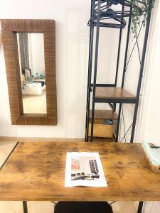 una mesa con espejo y un periódico. en Orchidea, en Bari